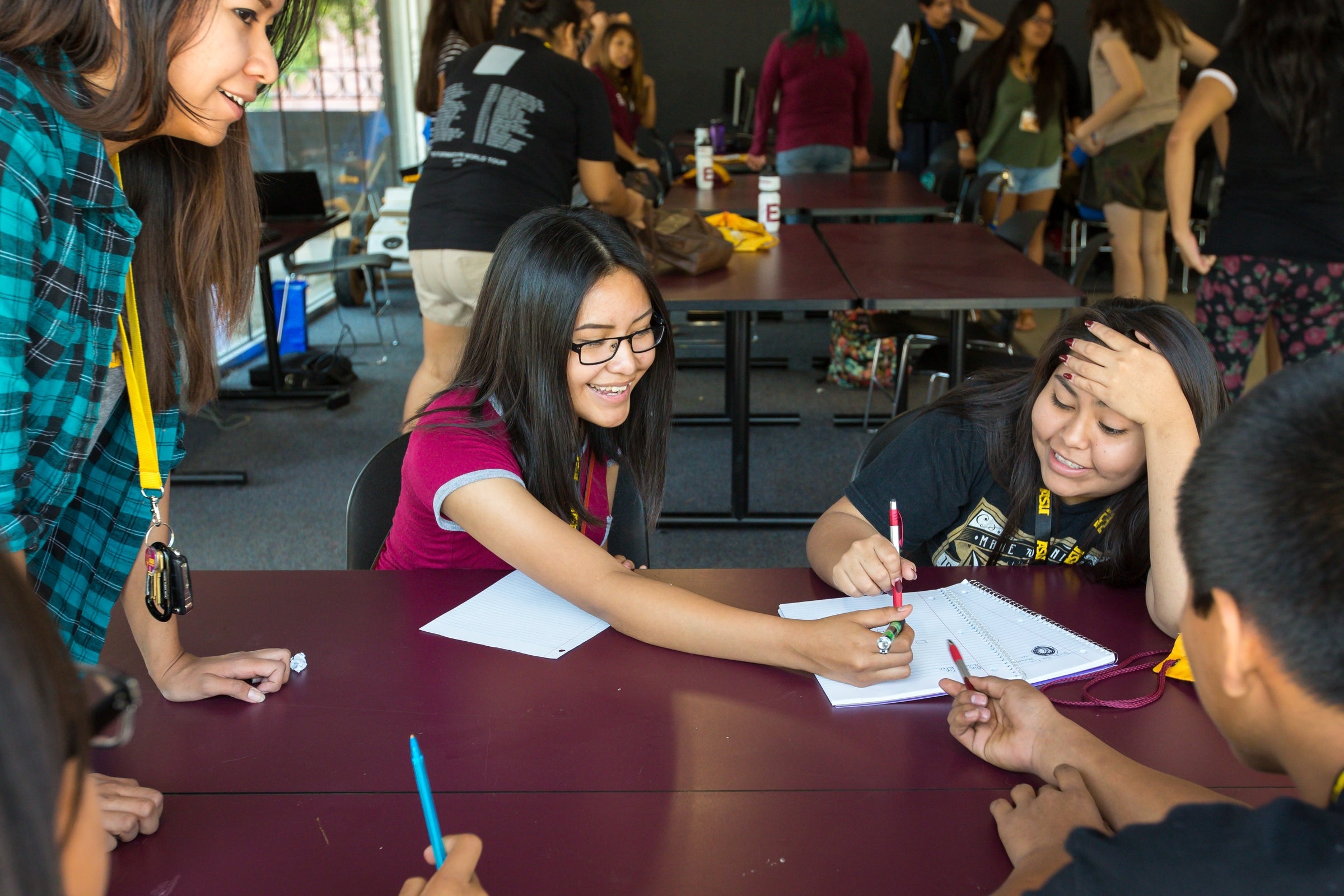 students sitting around table writing