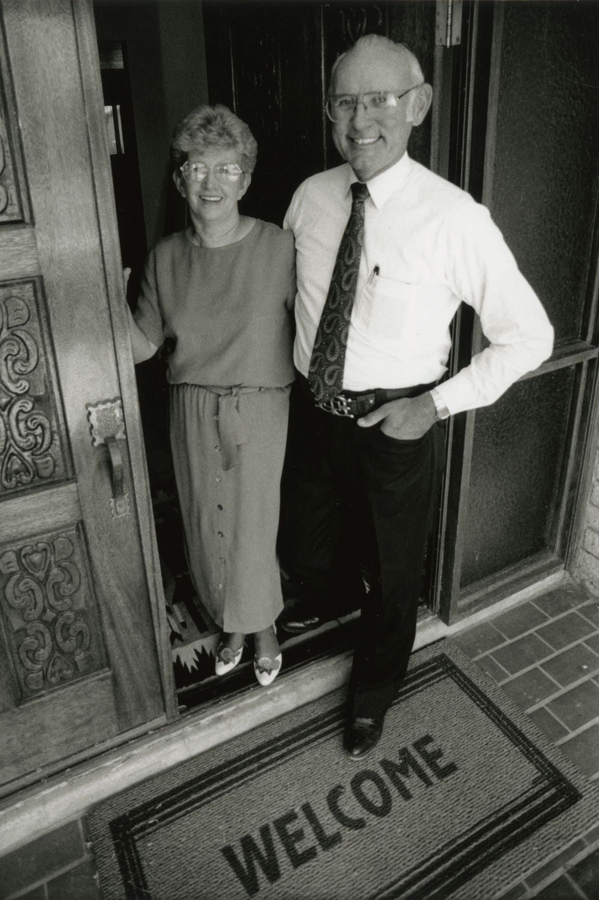 black and white photo of man and women at front door