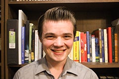 man posing in front of bookshelf