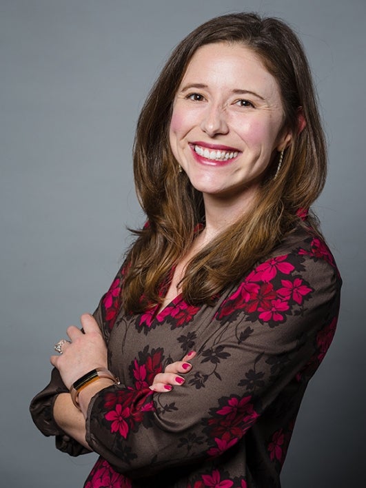  poses with her arms crossed in a portrait