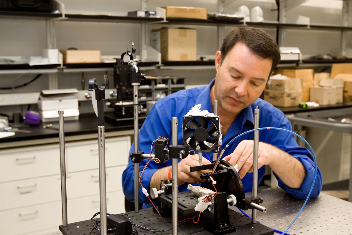 man building instrument in lab