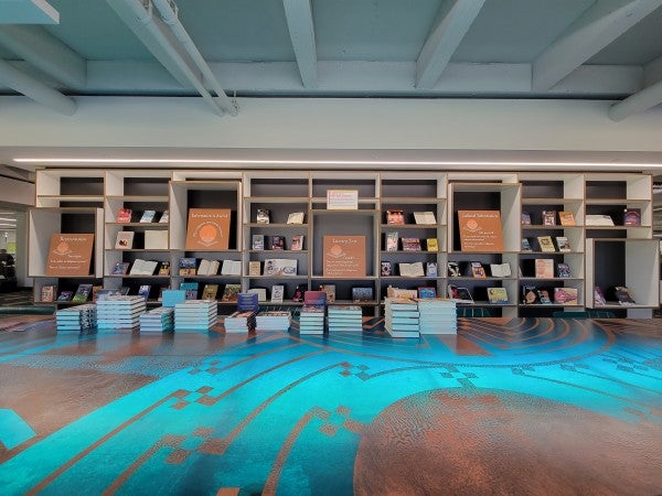 Books stacked on a table and displayed on shelves