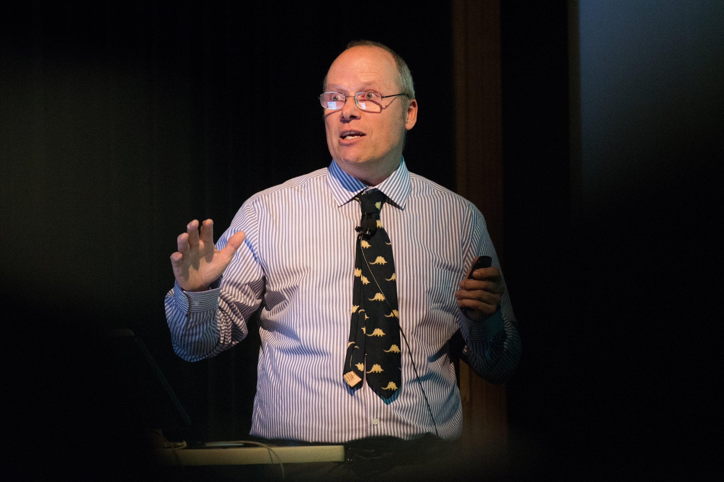 A man speaks at a lectern.