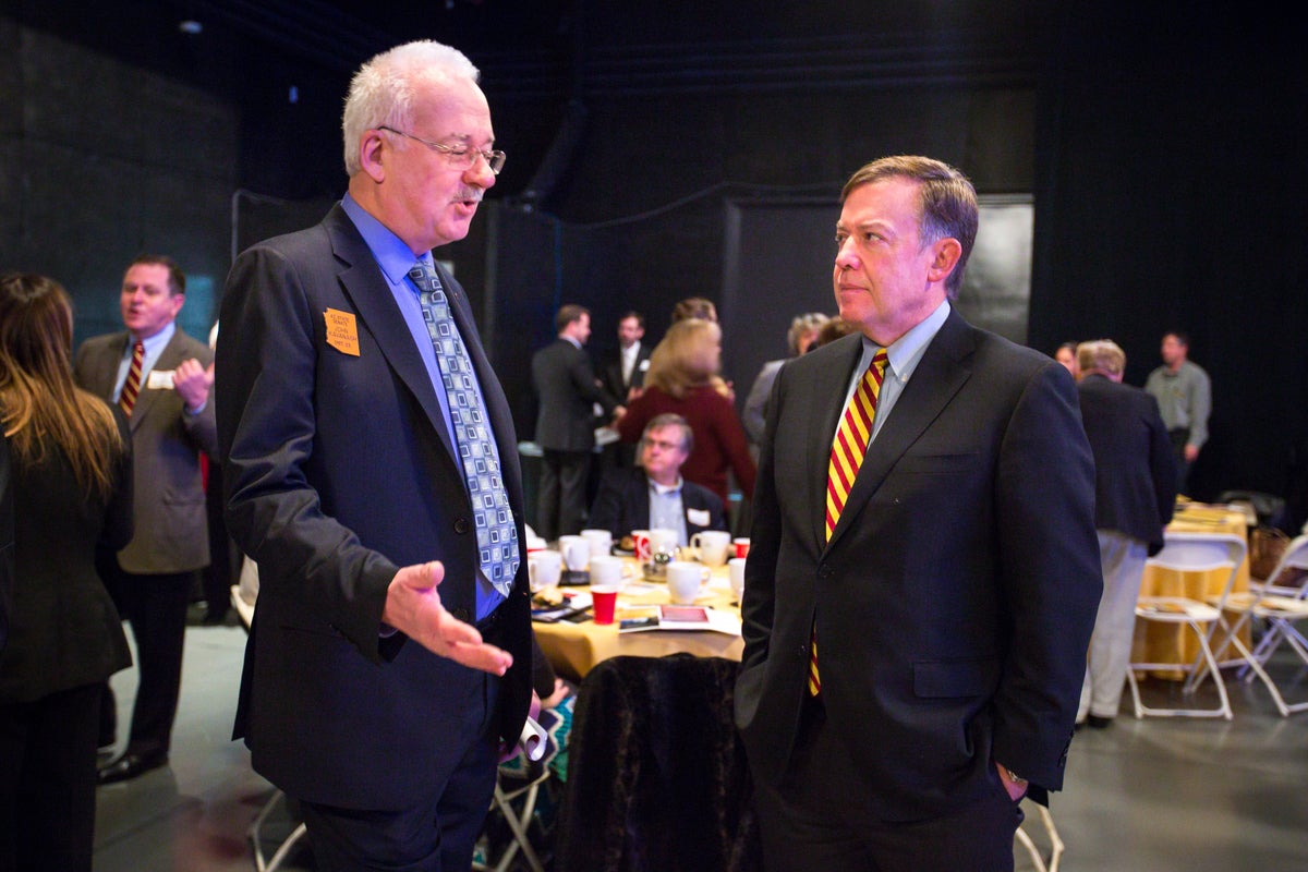 Men talking at an event.