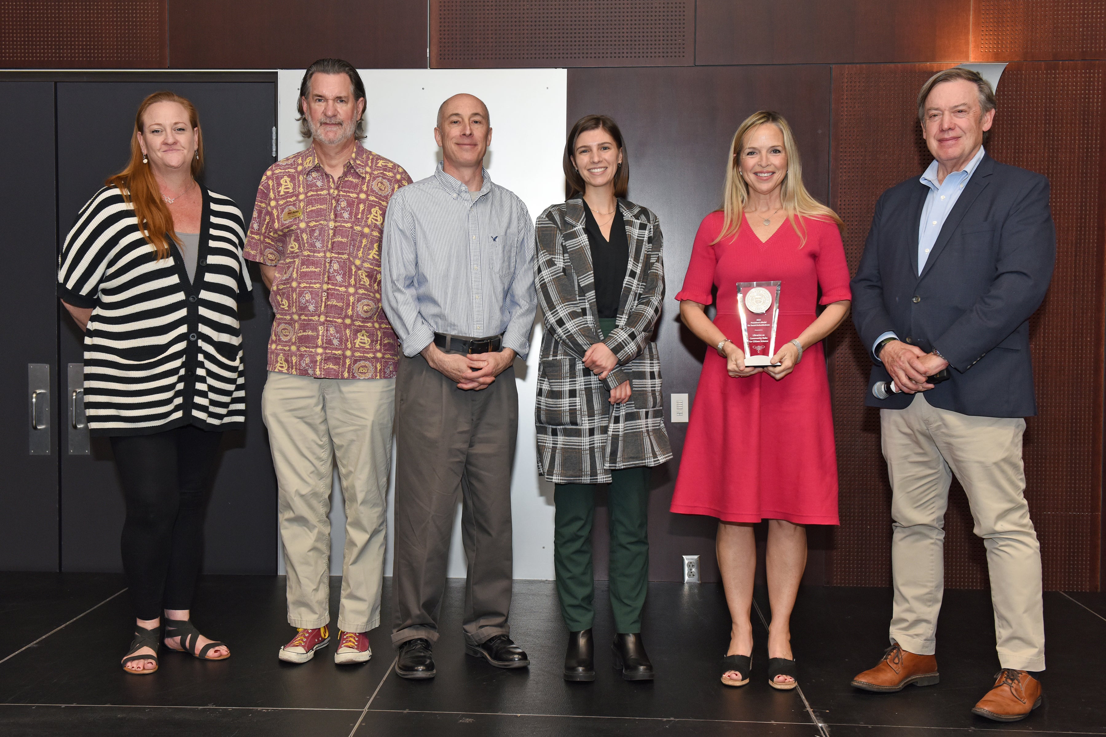 Group of people standing on stage with award