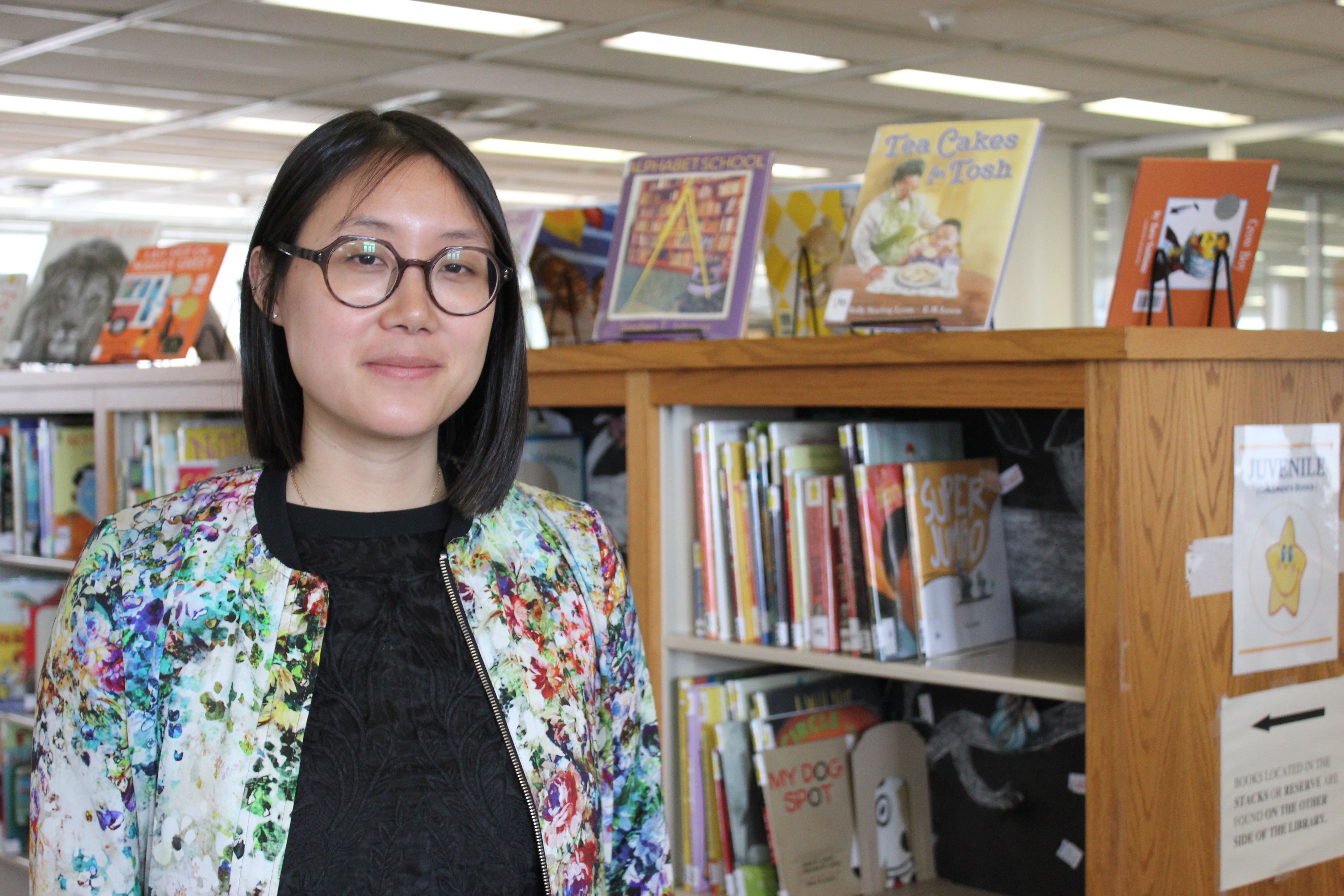 woman's portrait with bookshelves behind her