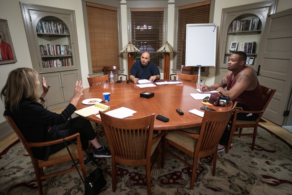 Three people talking at a round table