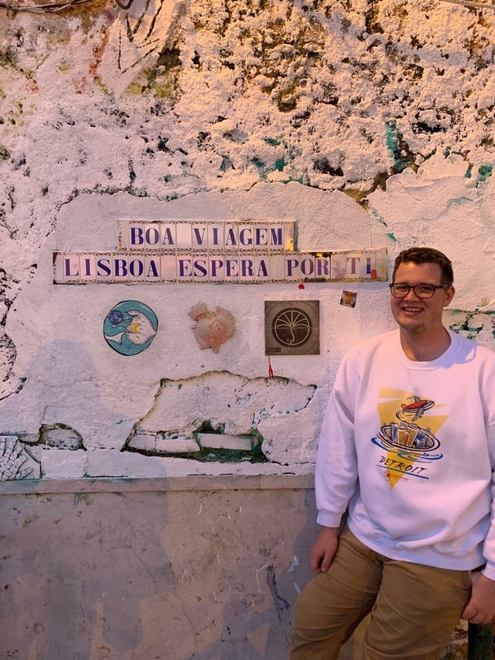 man in front of Portuguese sign 