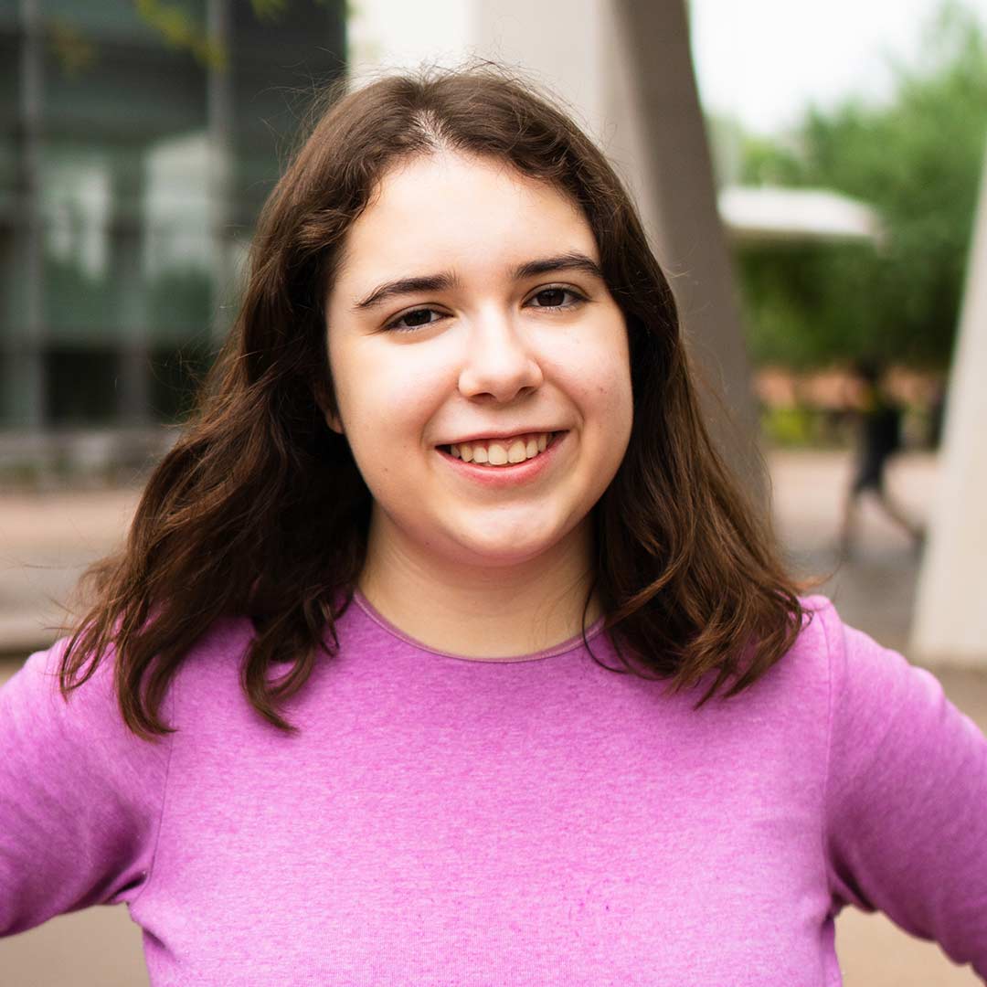 Undergraduate student  smiles at the camera.