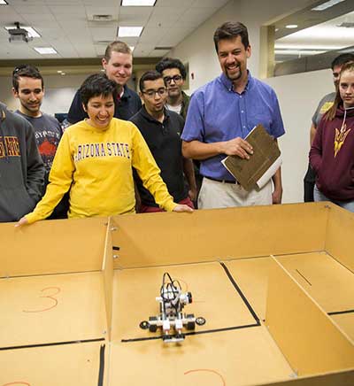 People looking at a robot in maze