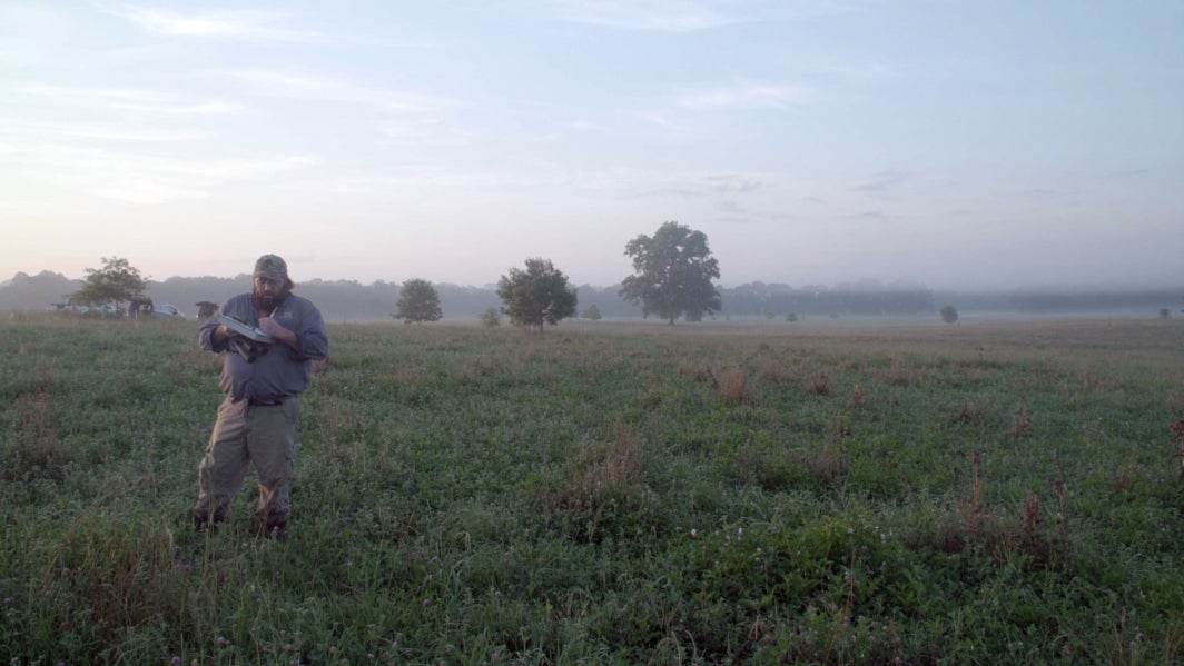 Man taking notes in grass field