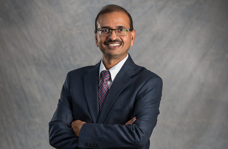 Man in black jacket and tie smiling