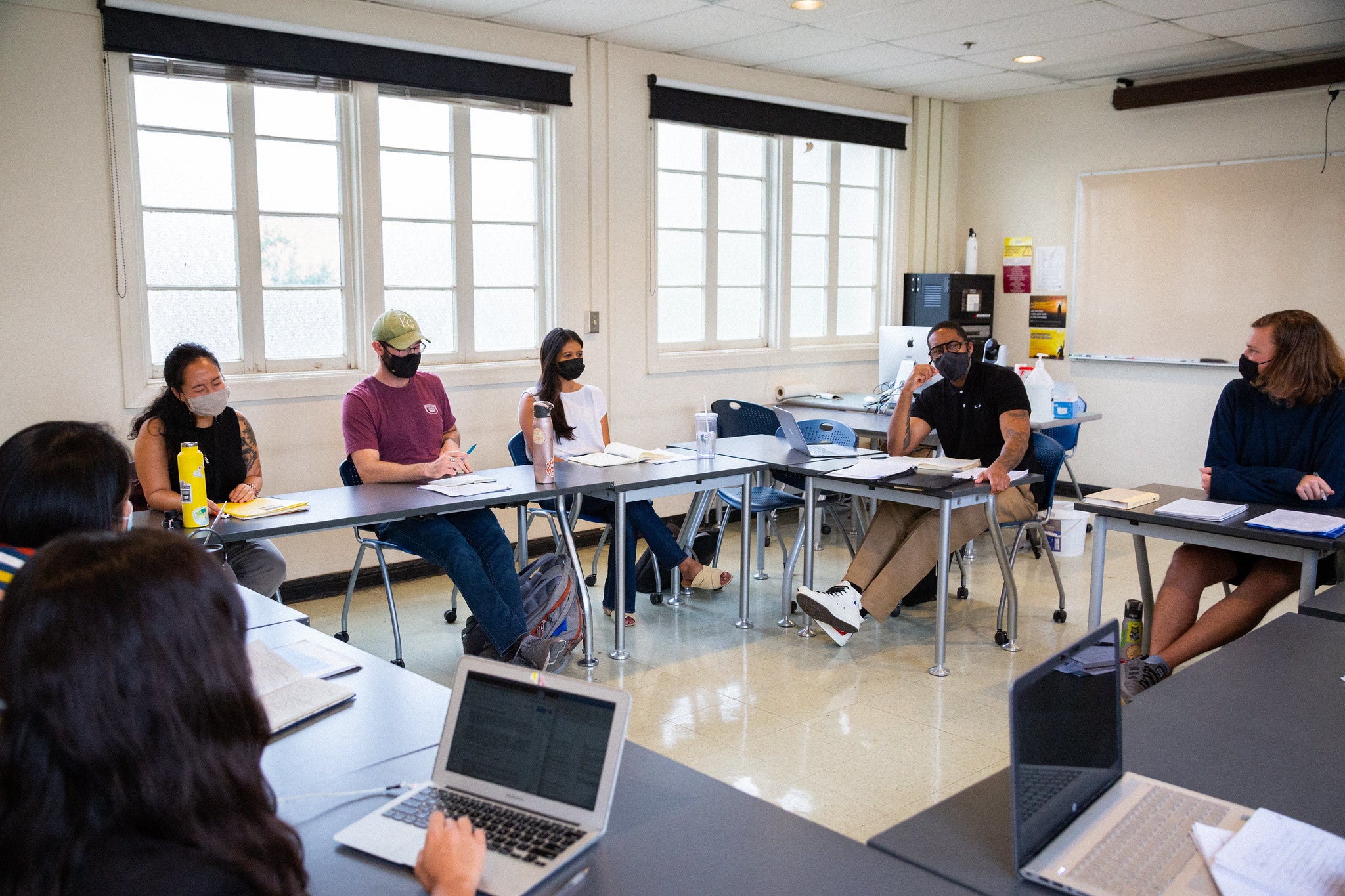 ASU Professor Mitchell Jackson seated in a classroom with students.