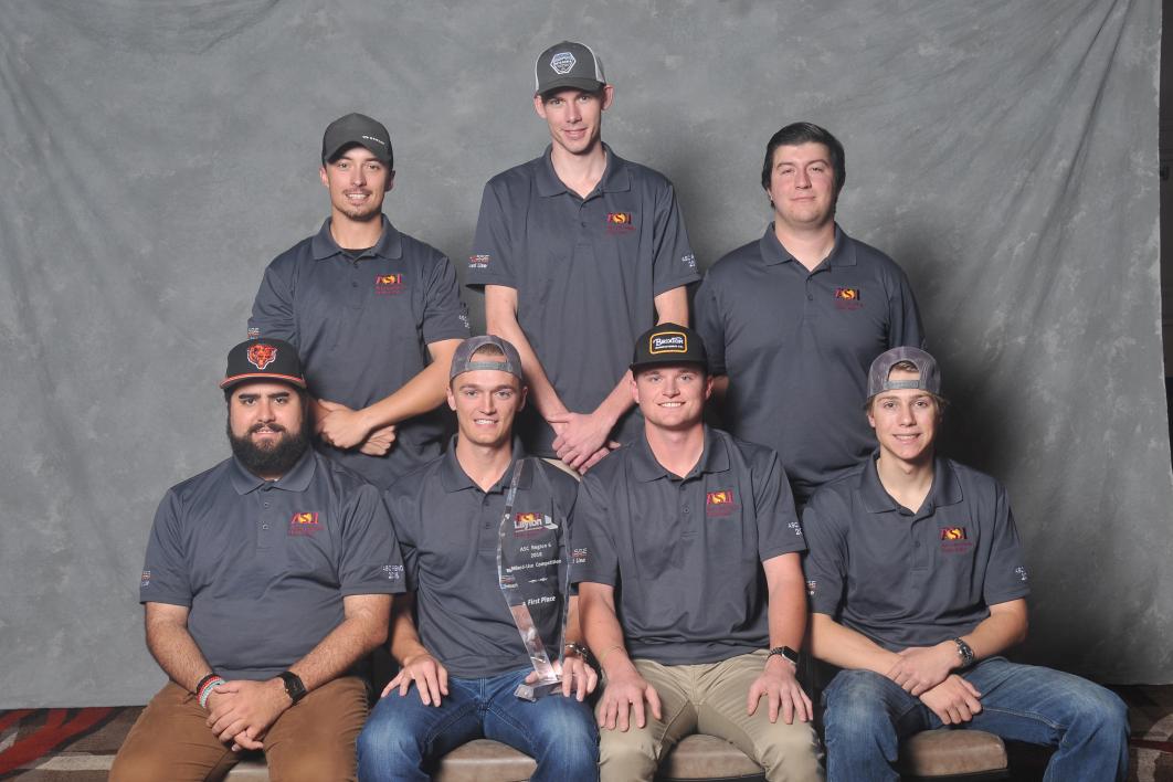 Photo of seven people posed with a trophy. 