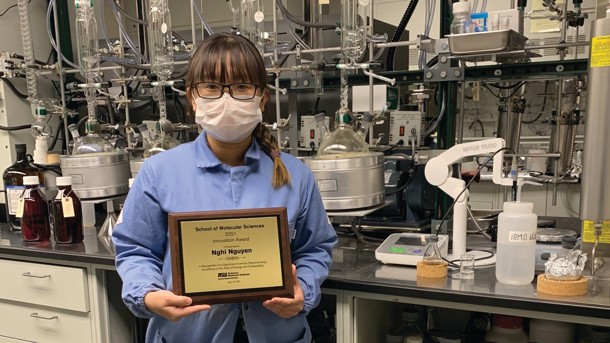 Nghi Nguyen holding her award plaque.