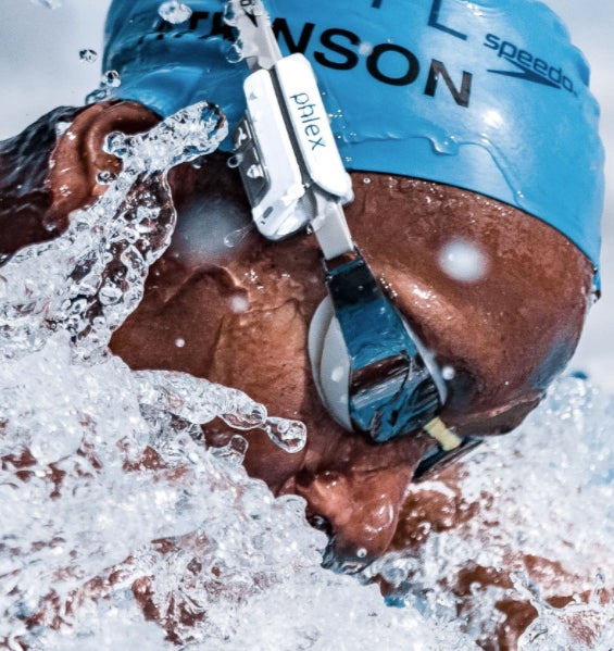 A swimmer swims wearing a cap and a device attached to their goggles