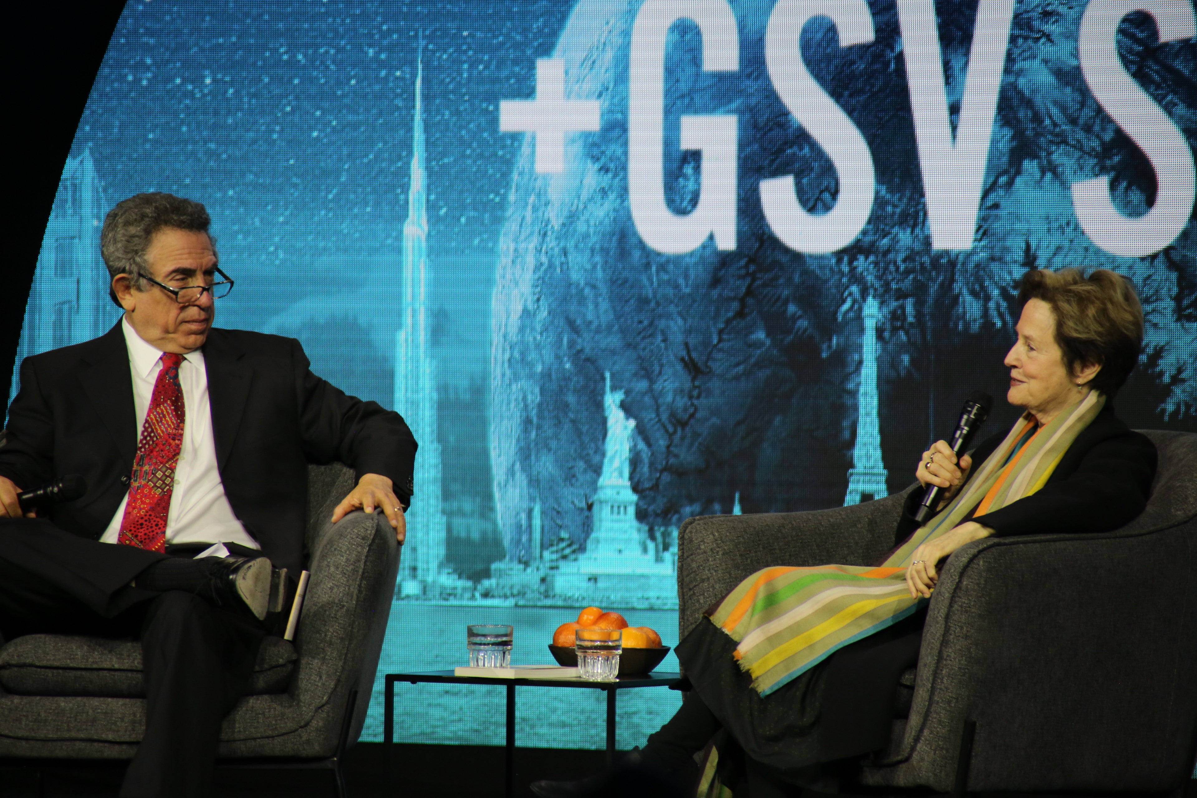 Two people sitting on stage during panel at summit