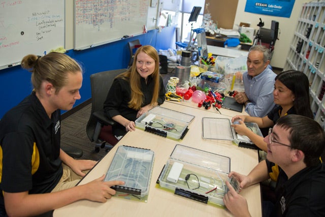 A group of engineering faculty and students at a table.