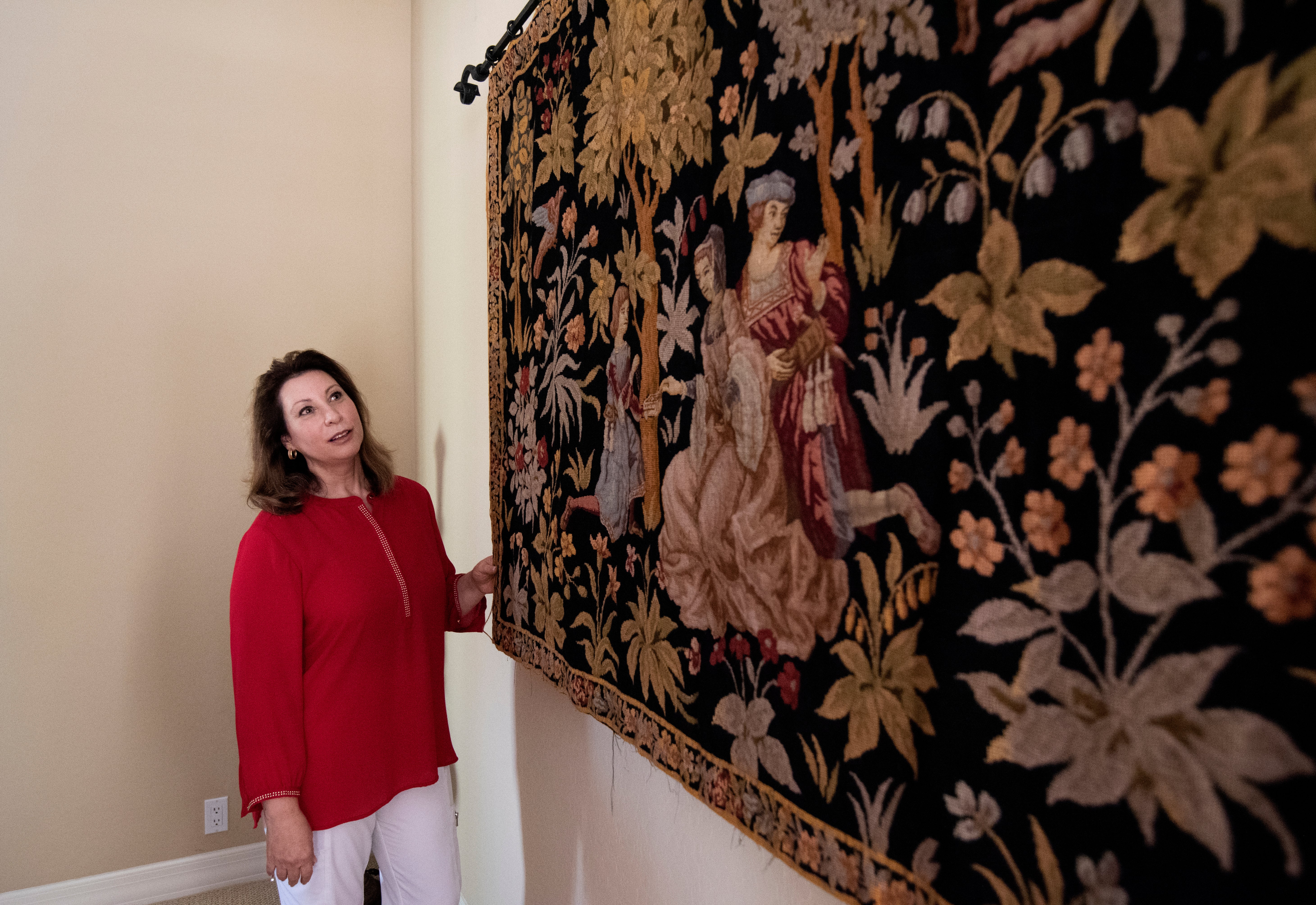 Ramona shows a wall tapestry from one of her family's global destinations. 