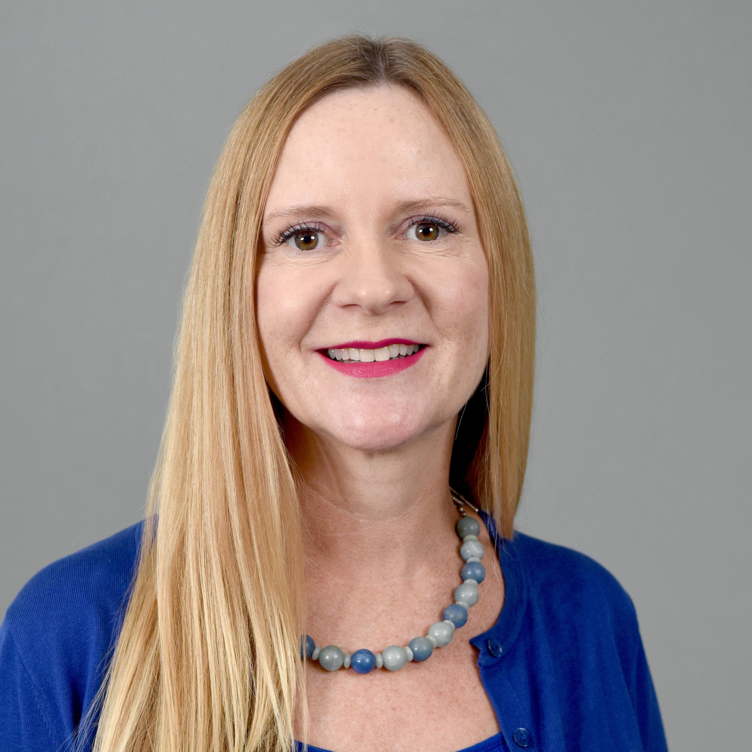 Headshot of Professor  in a blue top.