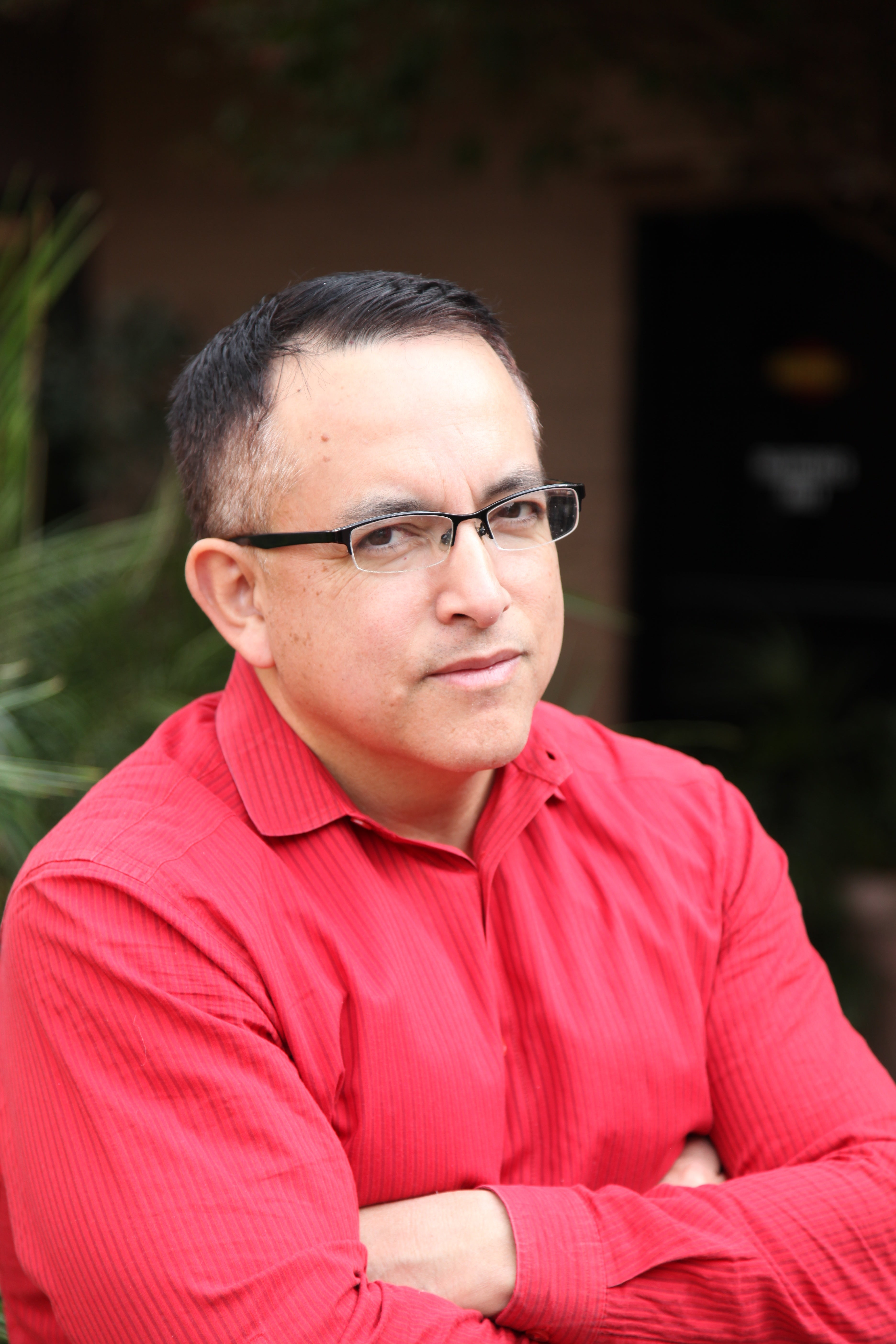 Man in red shirt with arms crossed