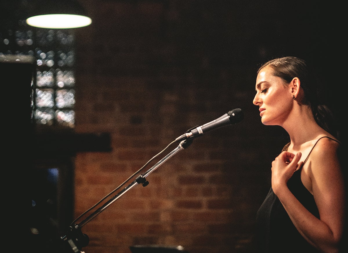 Grace Rolland, Rising Sun Daughter, performs live and sings into microphone