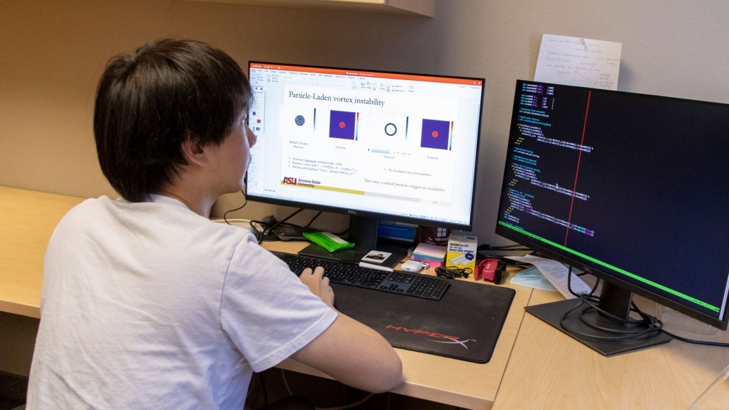 ASU mechanical engineering doctoral student Shuai Shuai looks at software code and simulation data on a computer.