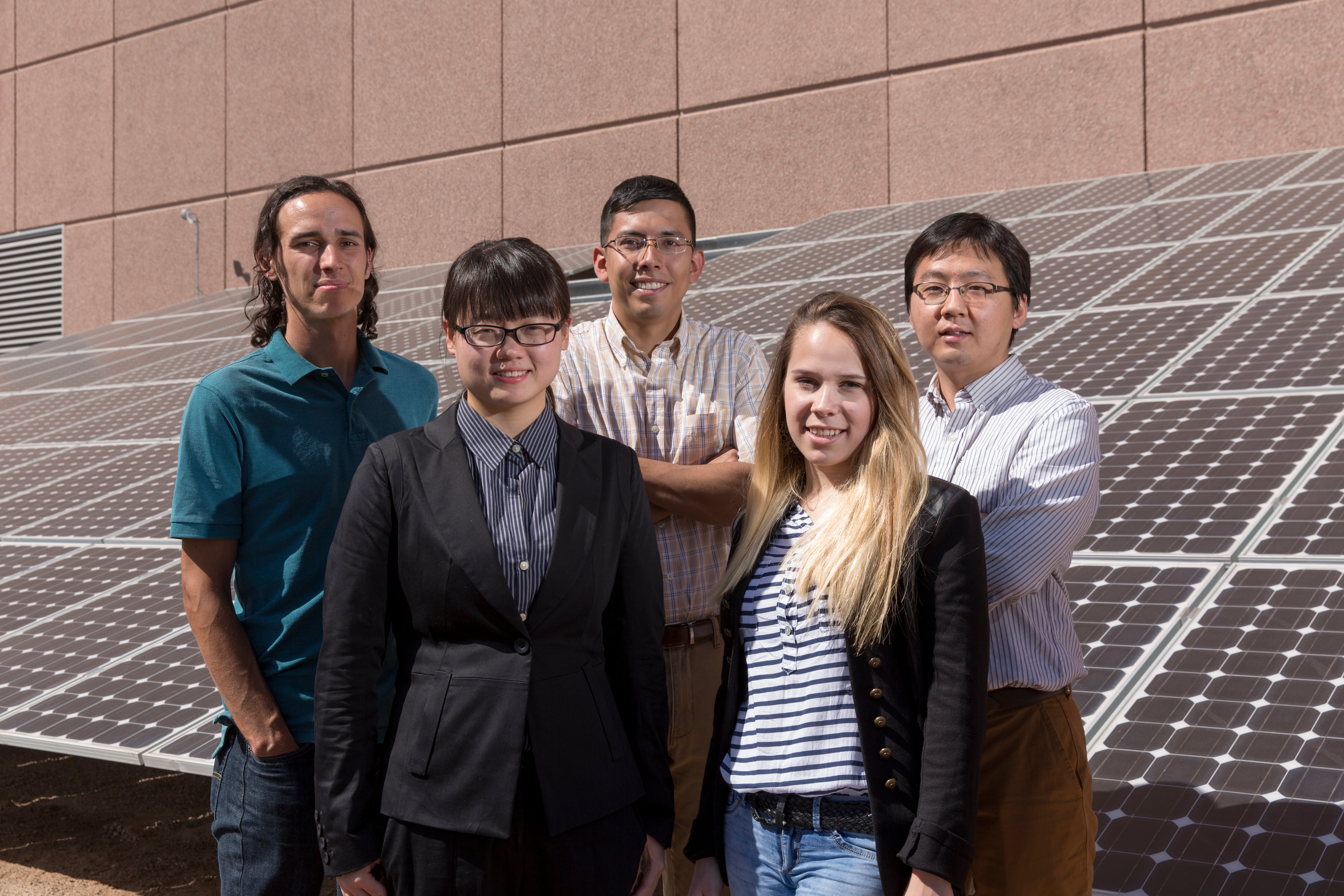 group standing in front of a solar panel