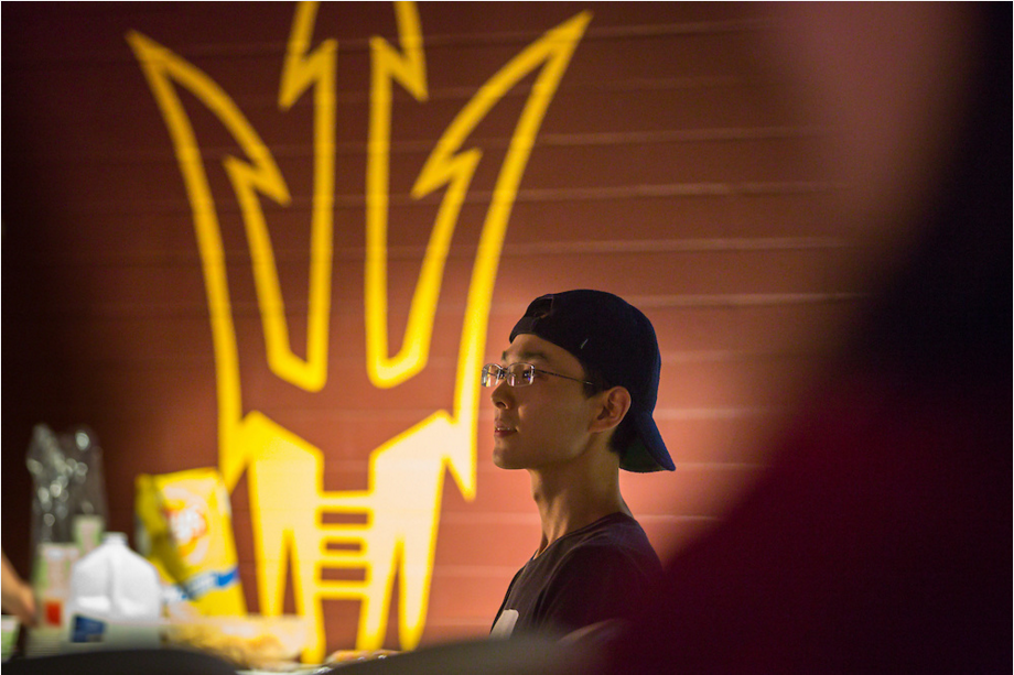 Student standing next to college logo.