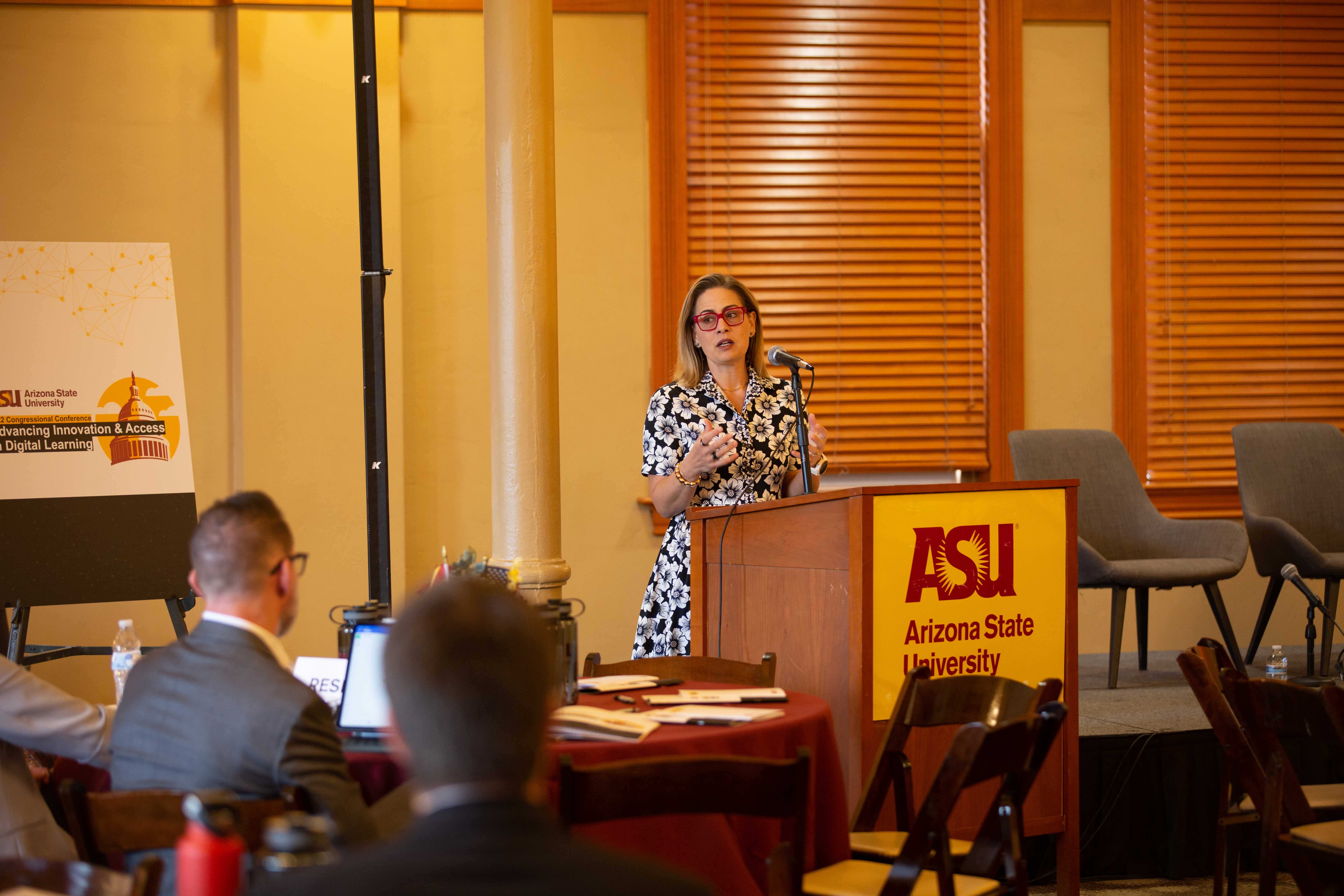 Sen. Krysten Sinema speaking at lectern at ASU