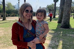 woman holding small child in park