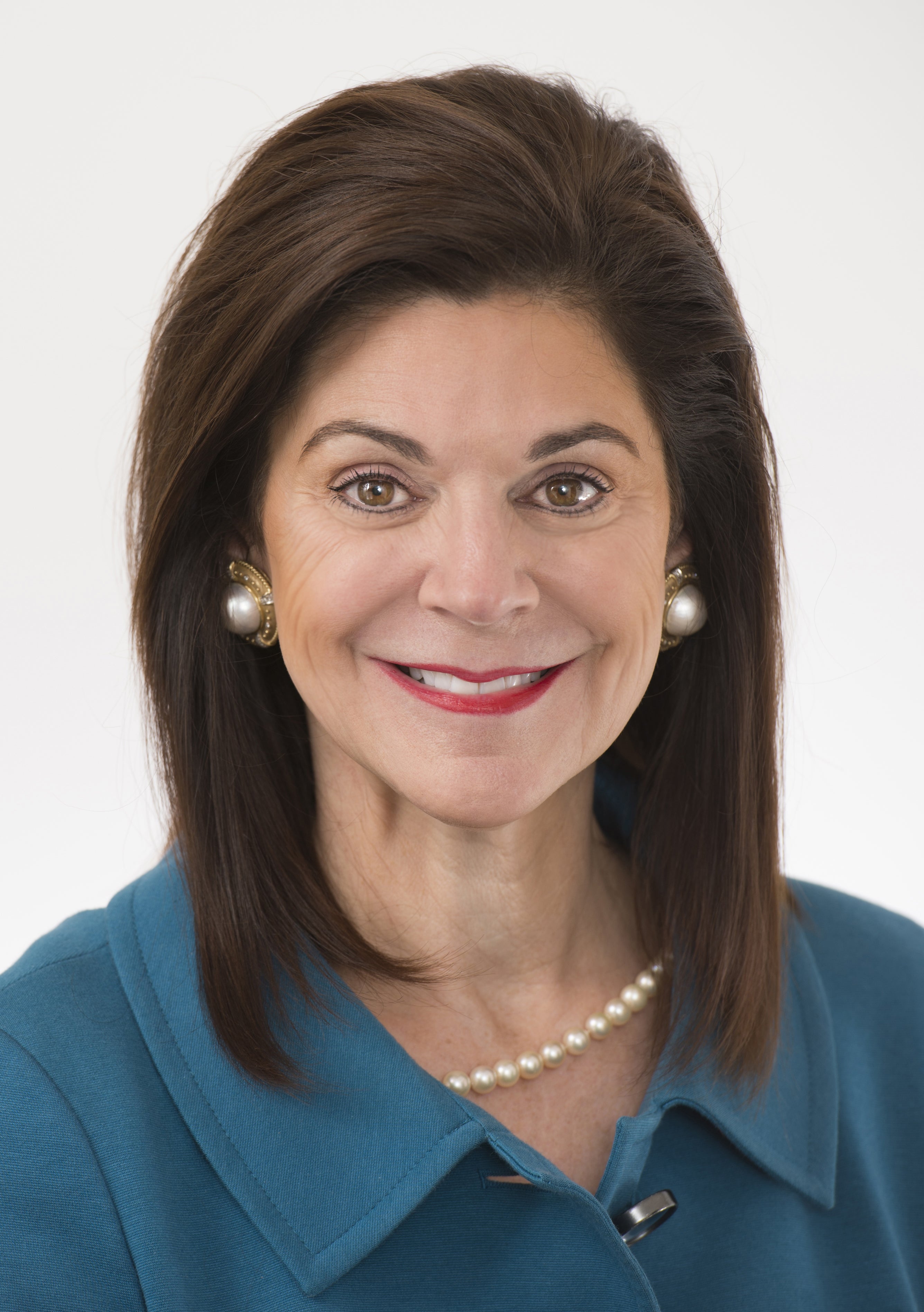 Woman with brown hair and pearls