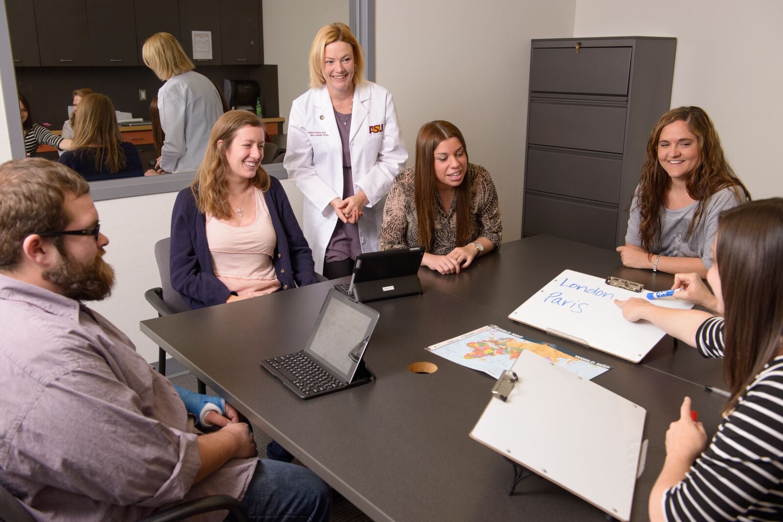 woman in white coat leading group discussion