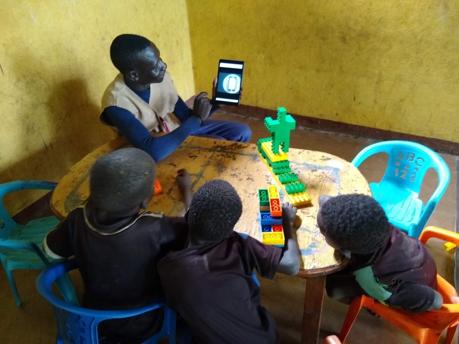 teacher at refugee camp using digital library to teach students