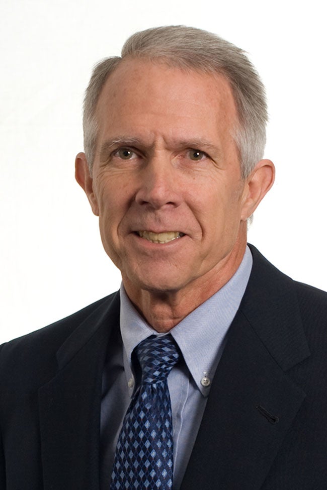 Man in blue suit and tie smiling