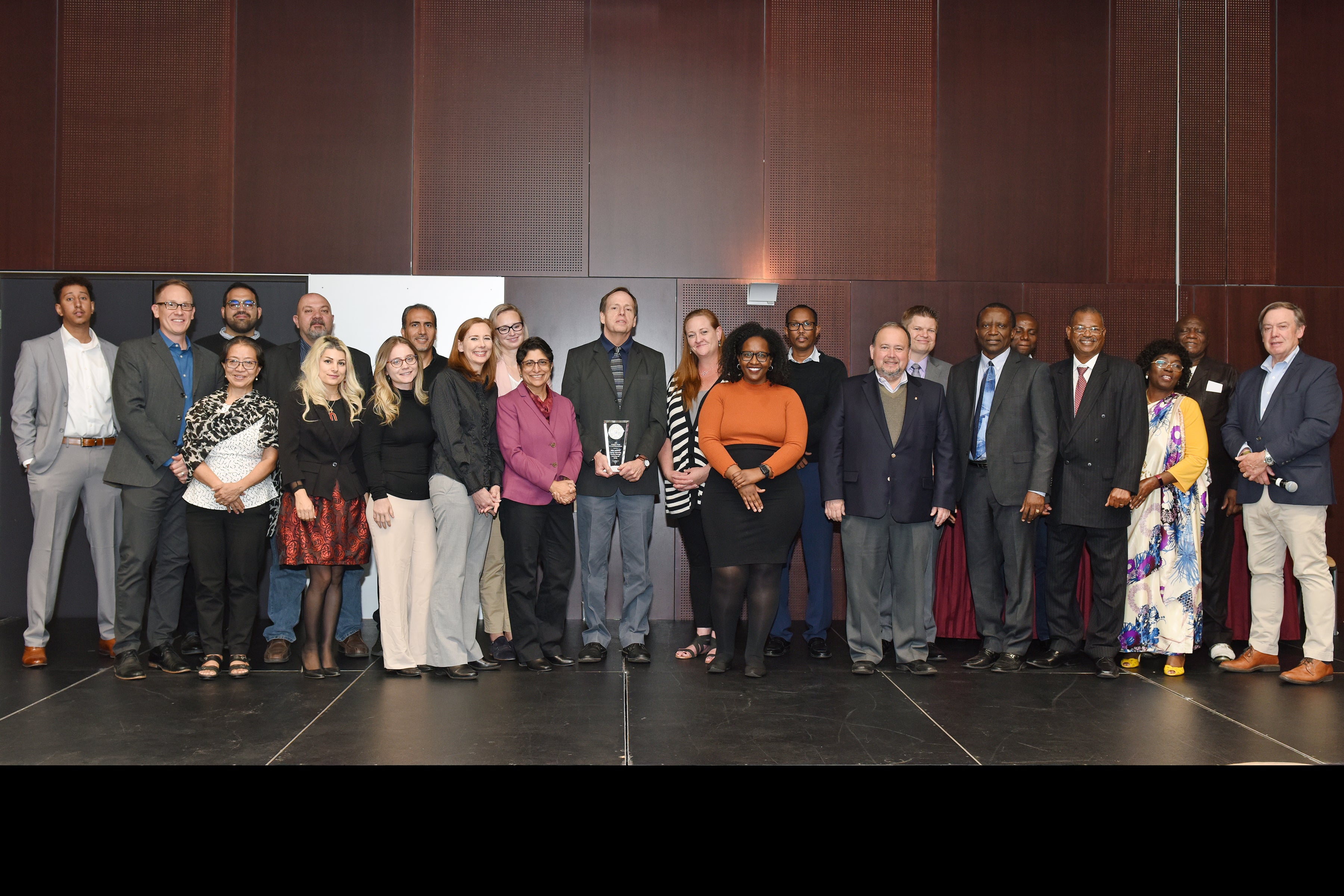 Large group standing on stage with award