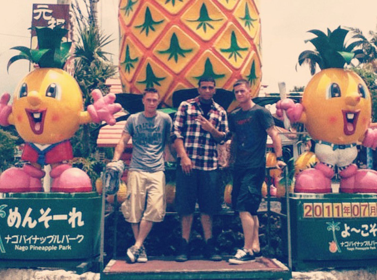 Three out-of-uniform Marines pose at a theme park in Okinawa, Japan