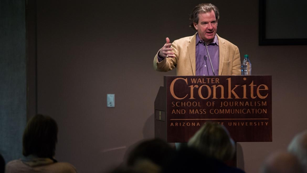 Man lecturing a crowd.