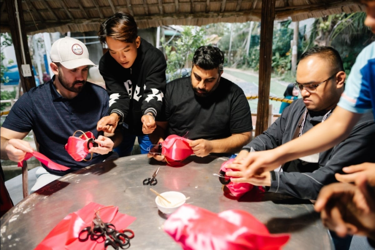 McCain Institute staffer Jaime Oliva, Australian MGL Charlie Shandil and Filipino MGL Ferth Vandensteen Manaysay create lanterns around a table in the historic city of Hoi An.