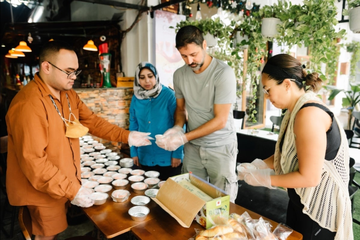 Filipino MGL Ferth Vandensteen Manaysay and Palestinian MGL Reham AlSaidi help package meals for sick kids at Hannah’s Restaurant in Da Nang.