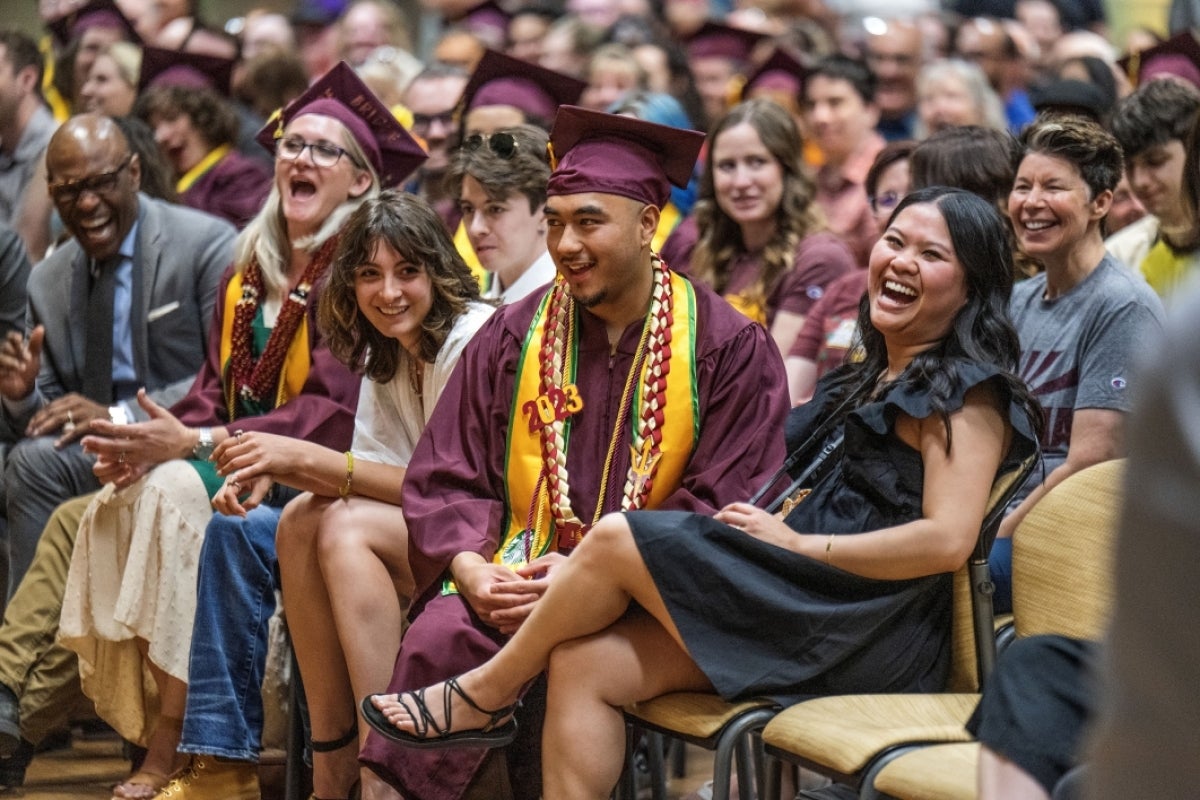 Students and family in audience smile during Starbucks graduate celebration