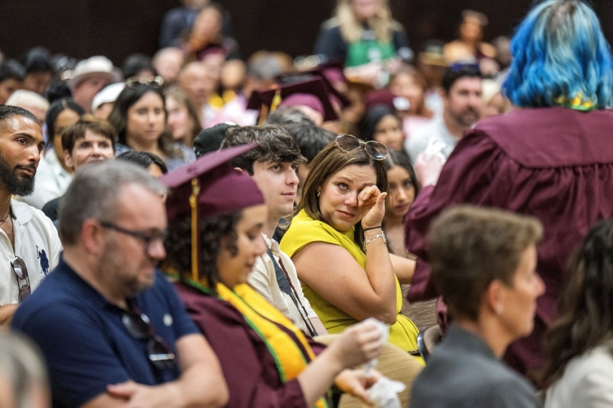 Woman tearing up in audience listening to graduate's story during Starbucks event