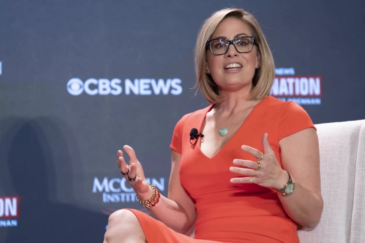 Kyrsten Sinema sitting on stage speaking in interview