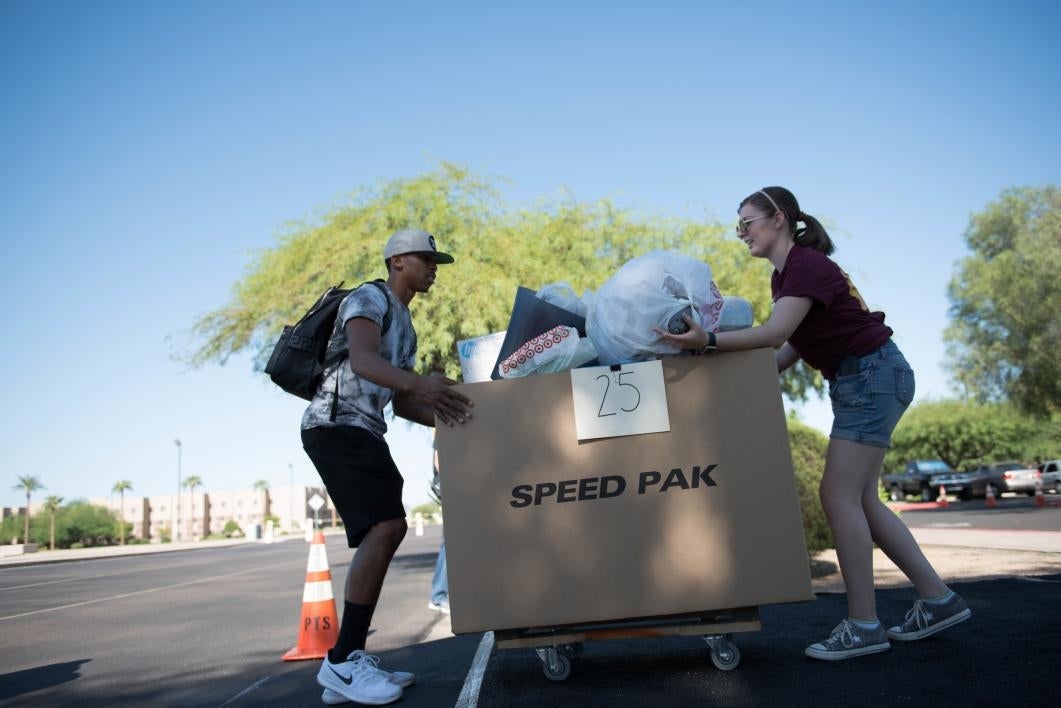 A student helps another move into the dorms on the West campus.