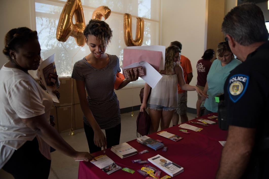 A student picks up safety brochures during move-in at West campus.