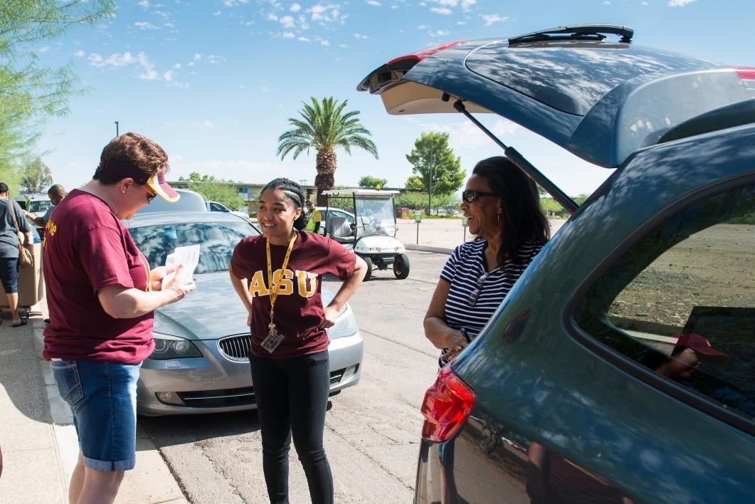 A new student smiles as she gets instructions on move-in on the Polytechnic campus.