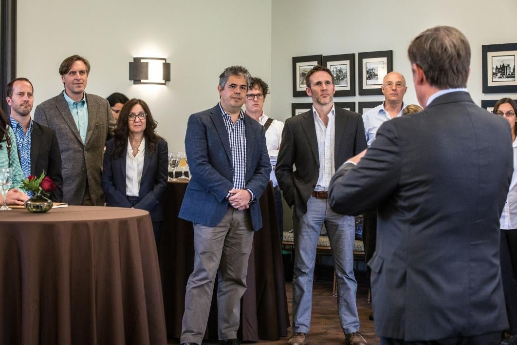 group of people listening to man speak