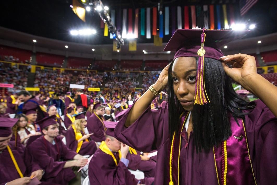 student adjusting graduation cap