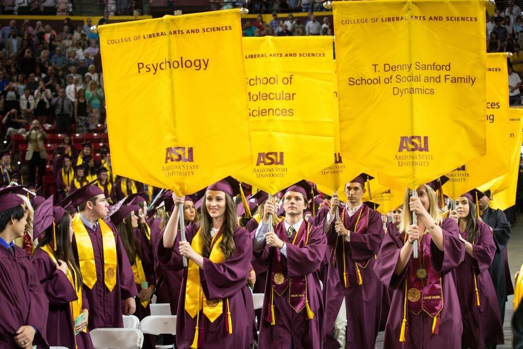 graduates carrying gonfalons