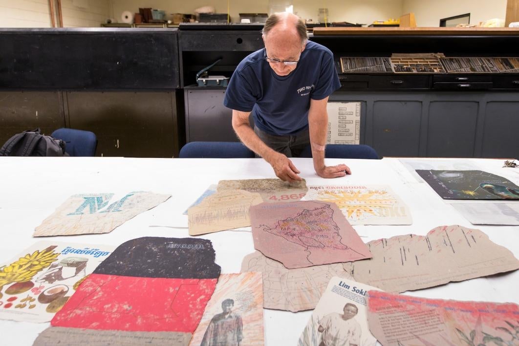 man looking at prints on table